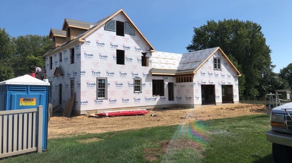 Large custom home under construction with Tyvek weather wrap and installed windows